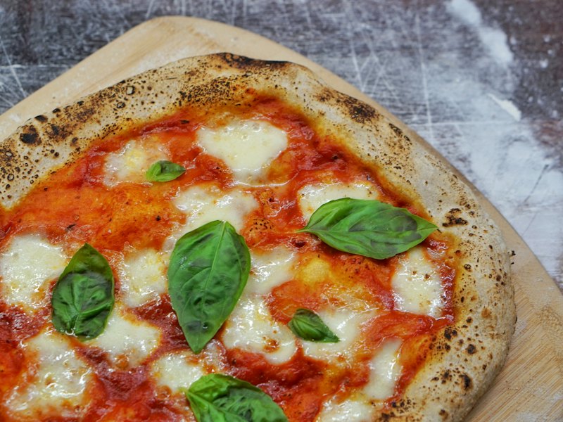 Pizza margherita con foglie di basilico